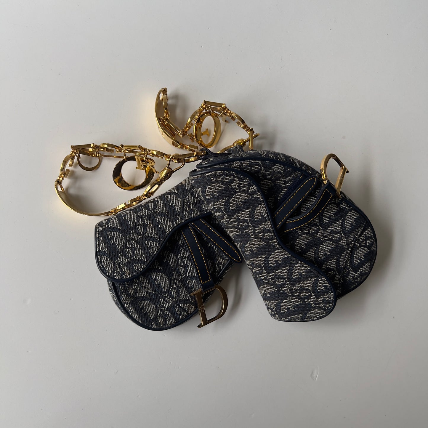 Vintage John Galliano era Dior Diorissimo Mini Saddle Charm Wristlet Bag in Navy Oblique Canvas with Gold-tone hardware.